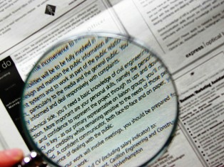 Magnifying glass over newspaper advertisements