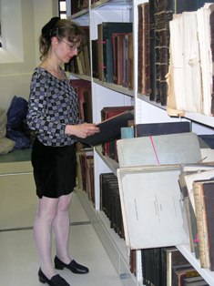 Librarian looking at leatherbound folios in a store